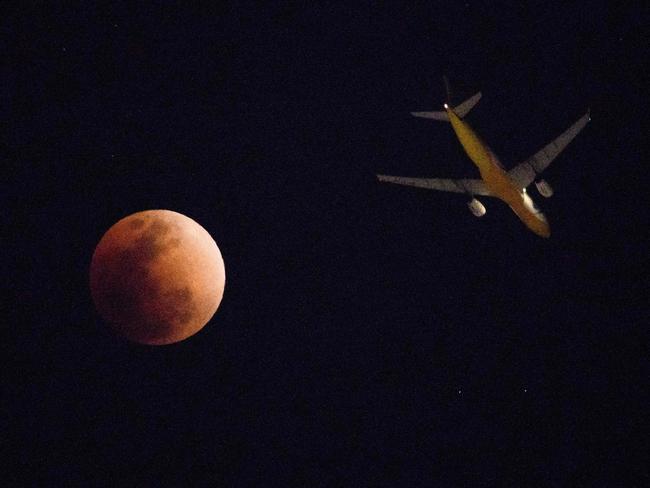 A plane is seen next to the super blue blood moon over Hong Kong. Picture: AFP