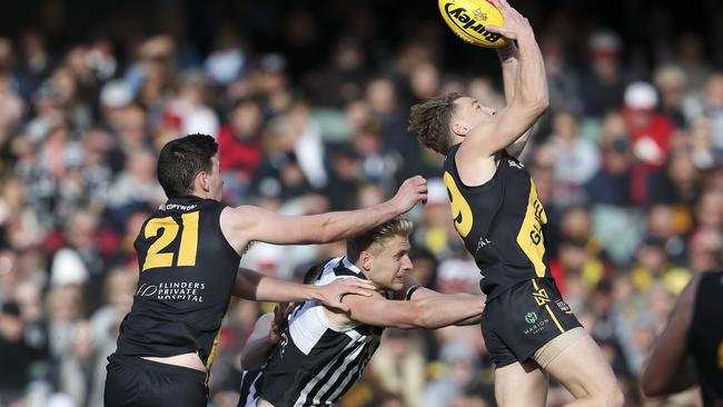 Glenelg’s Michael Virgin marks in front of Port’s Billy Frampton and Tiger Matthew Uebergang. Picture SARAH REED