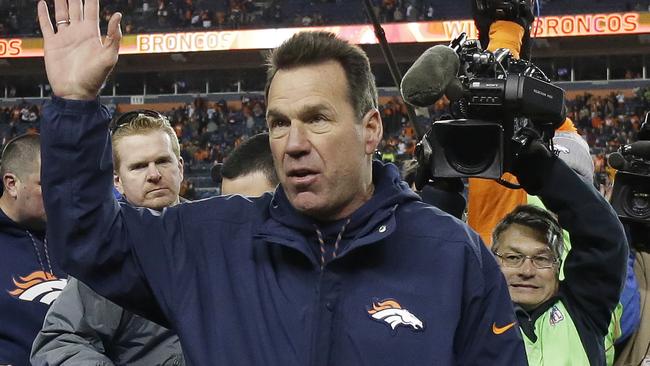 Denver Broncos coach Gary Kubiak waves as he walks off the field.