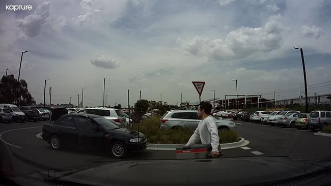 A man carried a car fridge from the ute at Middle Gorge train station in South Morang.