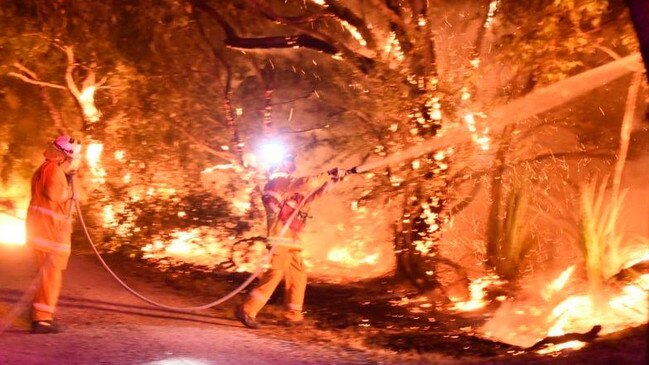 Crews were kept busy at Tarrara Lane, Bradbury, trying to prevent the fire from crossing the roadway. Picture: Brittany Norris/CFS