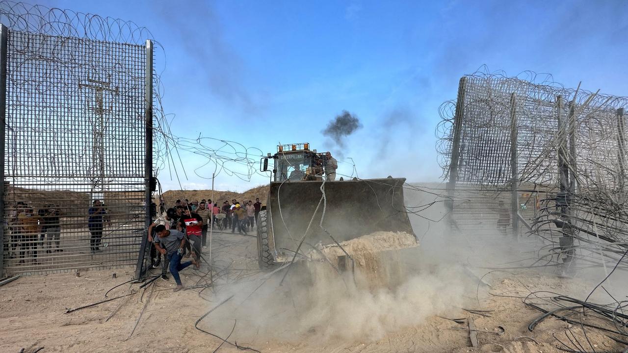 Palestinians break into the Israeli side of Israel-Gaza border fence after gunmen infiltrated areas of southern Israel on October 7, 2023. Picture: Reuters/Mohammed Fayq Abu Mostafa
