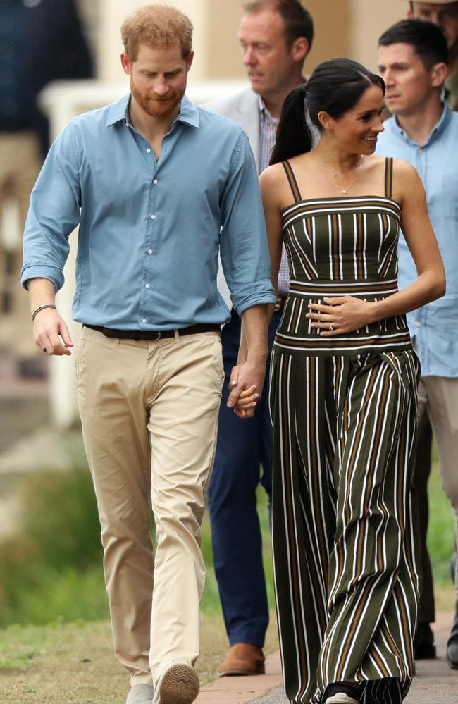 Meghan cradles her bump on Friday