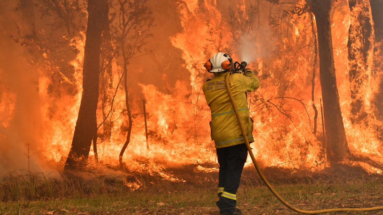 A firefighter conducts back burning to keep houses safe from bushfires moving towards them on the NSW Central Coast on December 10, 2019. Picture: AFP