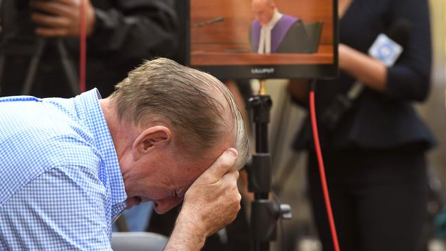 A man reacts as he listens to County Court Chief Judge Peter Kidd (on the monitor) speak during the sentencing. Picture: William West/AFP