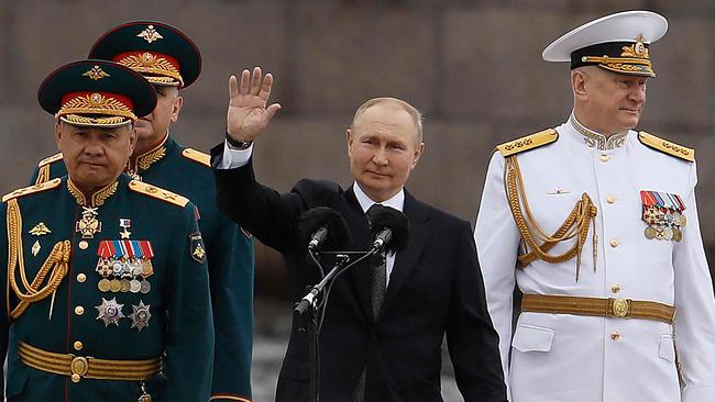 Russia's President Vladimir Putin (centre) waves next to Russia's Defence Minister Sergei Shoigu (left) and Commander-in-Chief of the Russian Navy, Admiral Nikolai Yevmenov (right) on Russian Navy Day, in St. Petersburg. Picture: AFP