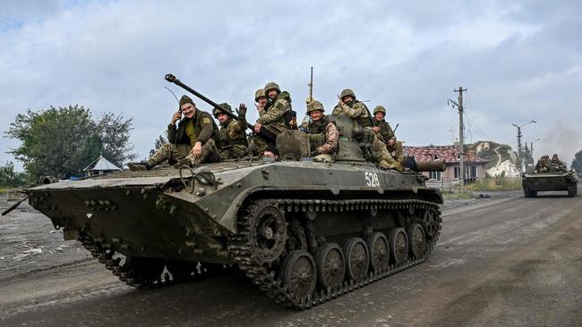 Ukrainian soldiers sit on infantry fighting vehicles as they drive near Izyum, eastern Ukraine. Picture: Juan Barreto/ AFP