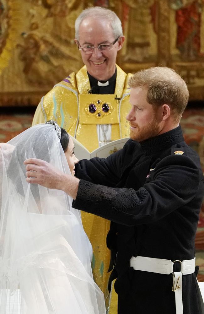 Prince Harry removes Meghan Markle’s veil  as they stand at the altar together before Archbishop of Canterbury Justin Welby. Picture: AFP