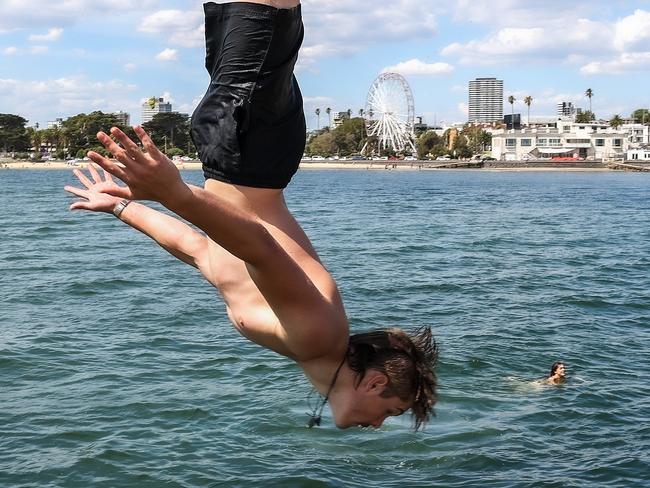 MELBOURNE, AUSTRALIA - NewsWire Photos 23 JANUARY 2022 : MelbourneÃs hot weather continues as the temperature hits the mid 30Ãs at St Kilda beach. Aster Frost jumps off St Kilda pier. Picture : NCA NewsWire / Ian Currie