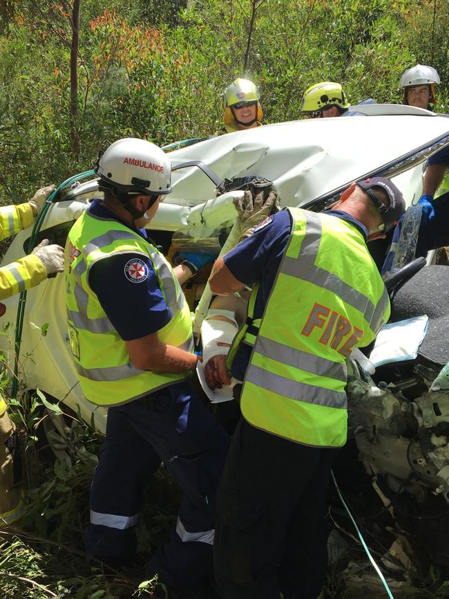 Paramedics and firefighters work to cut the teen free.