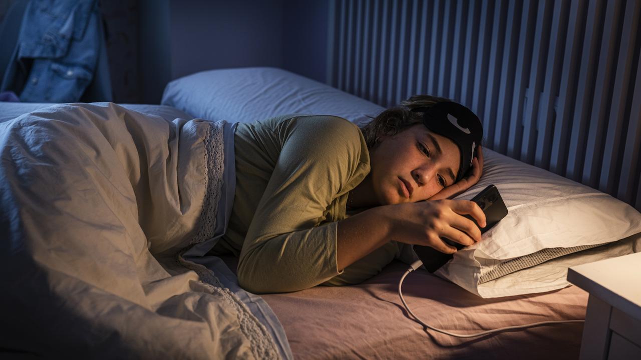 A teenage girl using a smartphone at night while unable to sleep. Picture: iStock