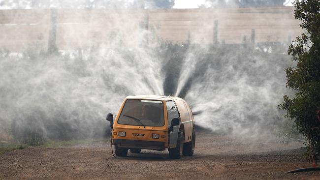 Property owners use a commercial watering machine to hose down their property as the Grose Valley Fire approaches Bilpin. Picture: AAP