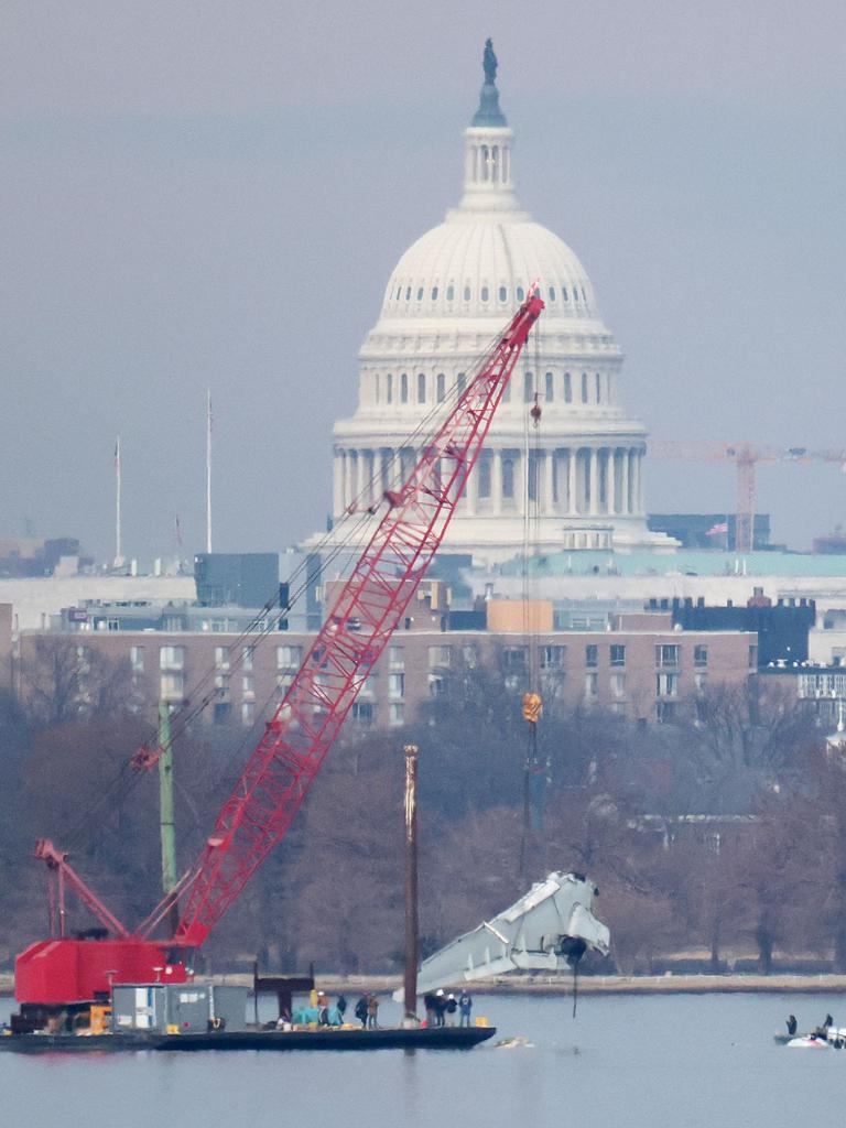 A crane lifts a piece of American Airlines flight 5342 from the Potomac River during recovery efforts. Picture: WIN MCNAMEE / Getty Images via AFP