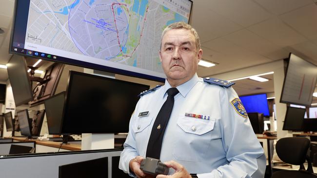 Corrective Services NSW’s electronic monitoring group general manager Andrew McClintock with a monitoring ankle bracelet and tracking screen at the Sydney HQ. Picture: Tim Hunter