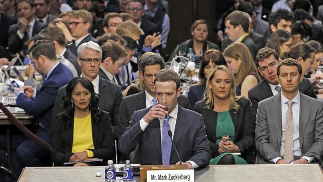 Mark Zuckerberg takes a water break during testimony.