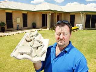 Plainland resident Shane Woods holds up some of the tiles damaged when lightning struck his home. . Picture: Claudia Baxter