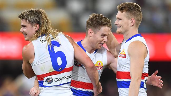 Lachie Hunter, middle, pictured with teammates Bailey Smith and Adam Treloar believes every player who has taken part in a game for premiership points should get a medal. Picture: Albert Perez/AFL Photos