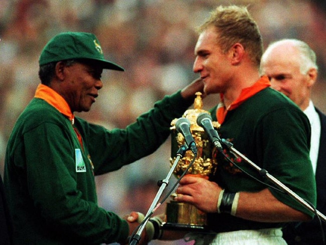 25/06/1995 LIBRARY: South African President Nelson Mandela (L) hands over William Webb Ellis Cup trophy to Springboks captain Francois Pienaar after South Africa defeated New Zealand All Blacks in 1995 World Cup (RWC) final at Ellis Park in Johannesburg, 24/06/95. Pic. Afp