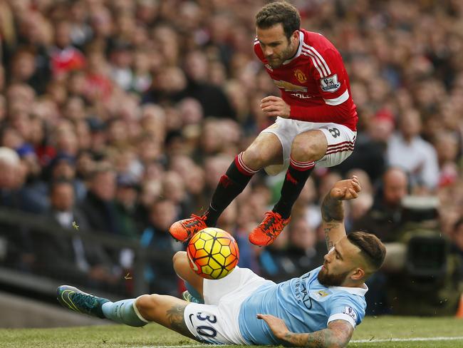 Juan Mata leaps over Nicolas Otamendi.