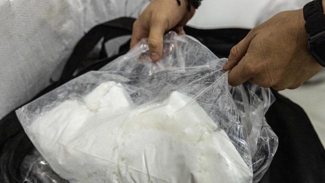 Patrol officer Jorge Vega shows more cocaine at a secure location in Cartagena, Colombia. Picture: Jason Edwards