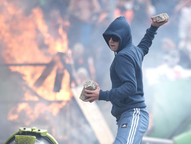 ROTHERHAM, ENGLAND - AUGUST 4: An anti-migration protester prepares to throw a piece of concrete during riots outside of the Holiday Inn Express in Manvers, which is being used as an asylum hotel, on August 4, 2024 in Rotherham, United Kingdom. Yesterday saw widespread violence as Far-right agitators in Liverpool and Manchester rioted and looted shops. Police were attacked and injured and dozens of arrests were made. (Photo by Christopher Furlong/Getty Images)