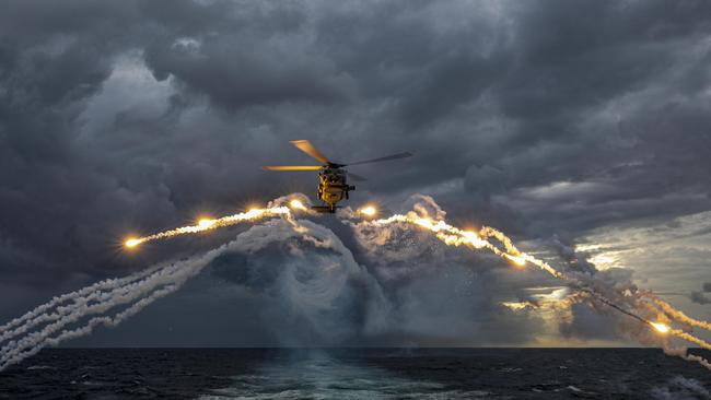 An MH-60R Seahawk helicopter from HMAS Parramatta deploys countermeasure flares on a training flight.