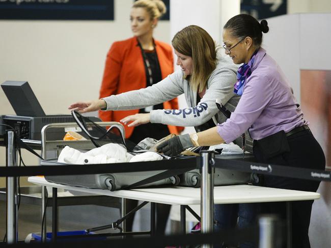 Security officers check luggage at Sydney airport following the terror raids last weekend. Picture: Justin Lloyd.