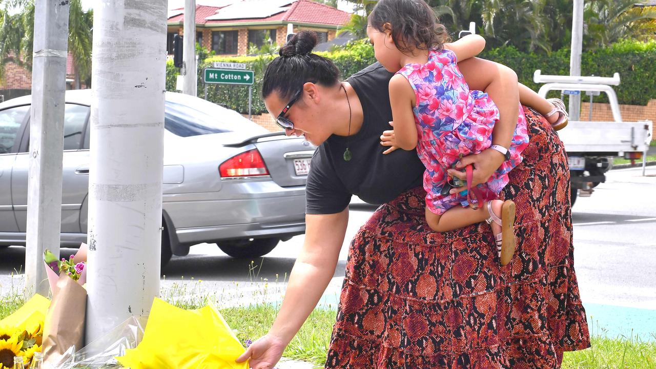 A woman places flowers at the scene of the horrific double fatality. Picture: John Gass