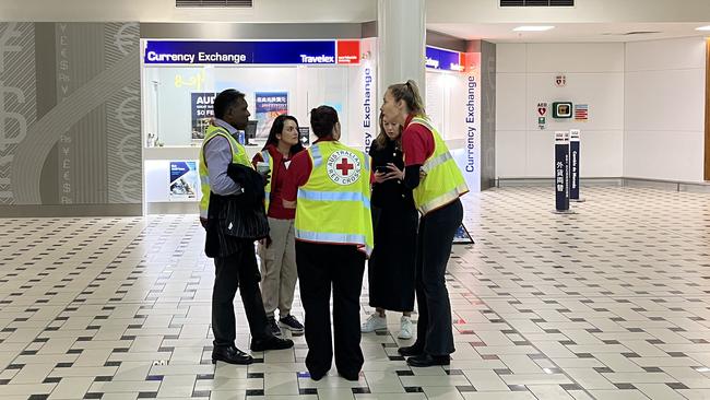 Red Cross await passengers from the turbulence-stricken Singapore Airlines flight at Brisbane Airport.