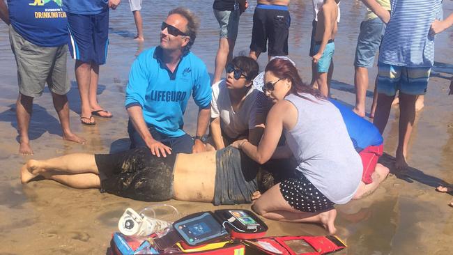 A lifeguard and onlookers perform CPR on the man at Lake Illawarra. Picture: Dylan Smith