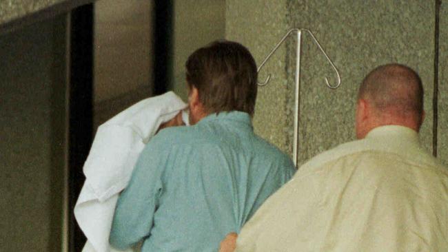 Police escort Neil Morrison from the Gold Coast Hospital days after the murders.