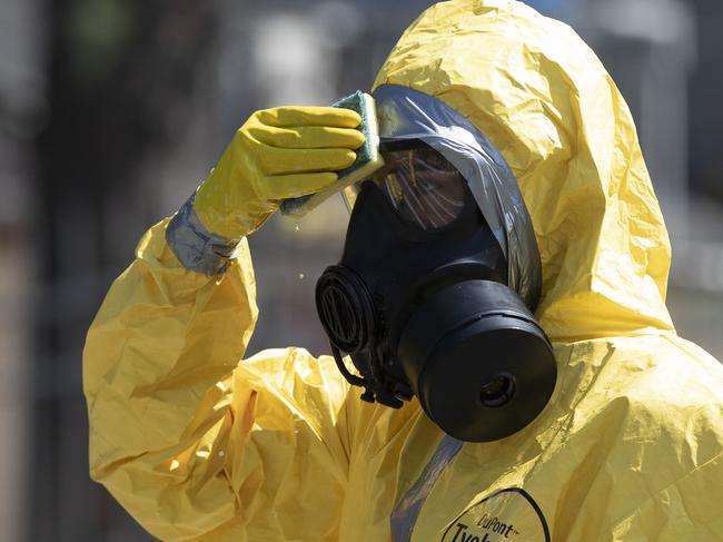 A Brazilian soldier in protective gear wipes his mask with a sponge during a media presentation of the military's preparations to fight against the new coronavirus, in Rio de Janeiro, Brazil, Tuesday, April 14, 2020. (AP Photo/Silvia Izquierdo)