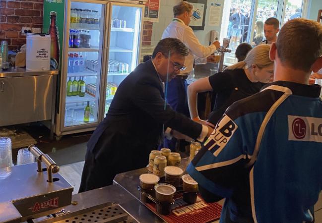 Cronulla boss Dino Mezzatesta serving beers at Shark Park.