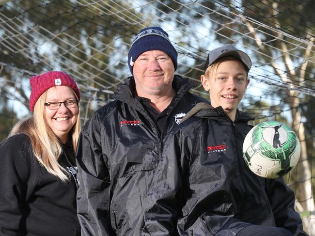 Para Hills Soccer Club is raising money and awareness for brain cancer, in support of club junior assistant coach Shane Hillman, who is terminally ill with the disease. Shane with his 15-year-old son Josh and wife Deb at Para Hills Soccer club, 9 June 2018. (AAP Image/Dean Martin)