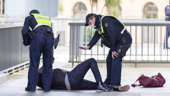 Police detain a men who interrupted the press conference on Wednesday. Picture: NCA NewsWire / Wayne Taylor