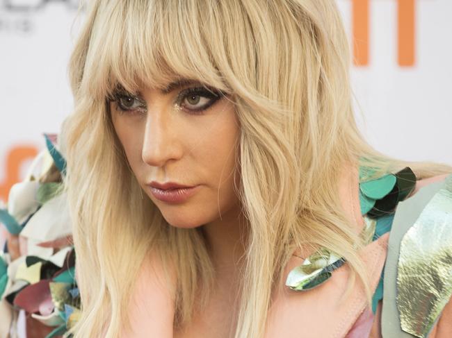 Lady Gaga poses for photographers outside the Princess of Wales Theatre as she arrives for the premiere of her movie 