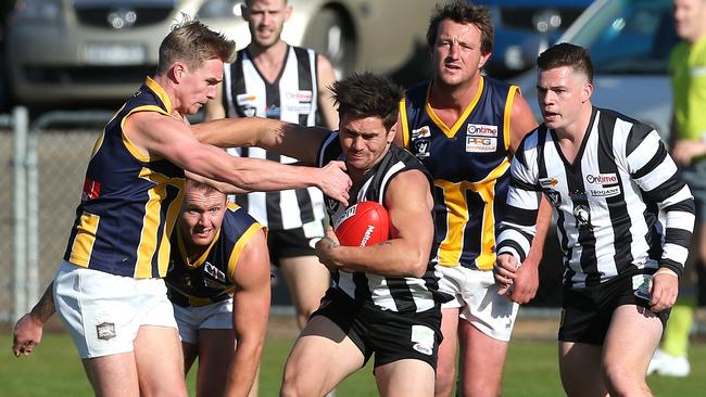 Wallan’s Jesse Davies tries to push clear of a tackle from Rupertswood’s Lachie Muir. Picture: Hamish Blair.