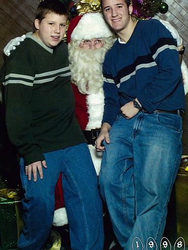 With similar sweaters, Mike, 18, and Martin 14, pose with Santa. Picture: Martin Gray