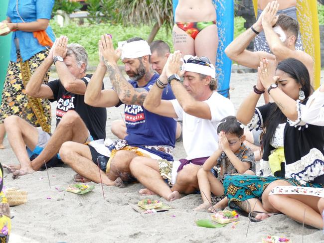 Damien Rider (purple shirt) prepares for a paddle-out in Bali to honour victims of child abuse and suicide.