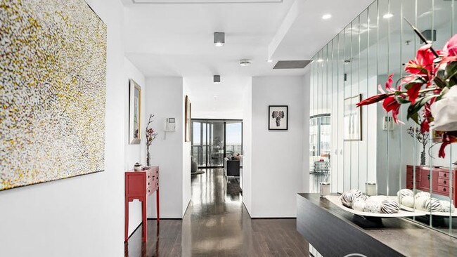 A mirrored hall leads to the home’s living and dining area.