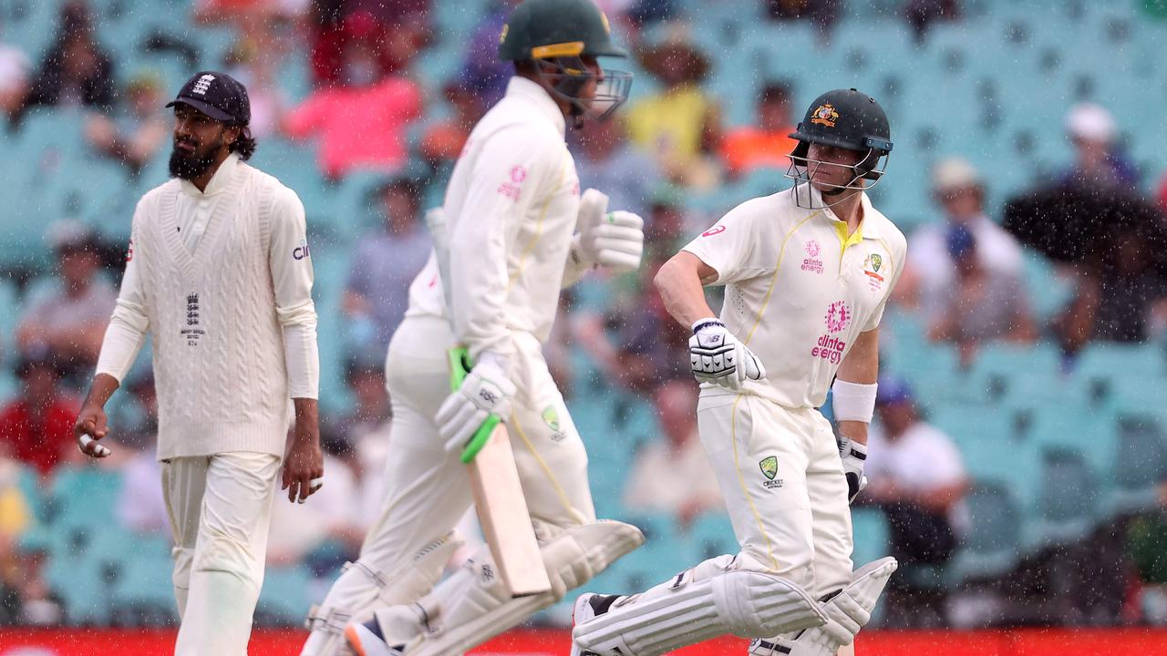 Australia's batsmen Steve Smith (R) and Usman Khawaja walk off the field as rain delay the day one's play of the fourth Ashes cricket Test match between Australia and England at the Sydney Cricket Ground (SCG) on January 5, 2022. (Photo by DAVID GRAY / AFP) / -- IMAGE RESTRICTED TO EDITORIAL USE - STRICTLY NO COMMERCIAL USE --