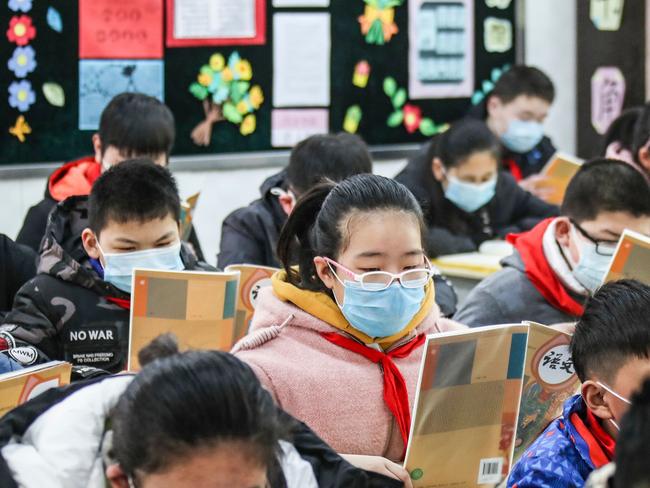 Elementary school students wearing face masks attend a class as they return to school in China. Picture: AFP