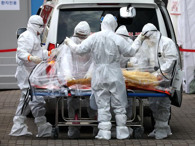 Medical staff move a patient infected with the coronavirus from an ambulance to a hospital in Seoul, South Korea. Picture: Getty Images