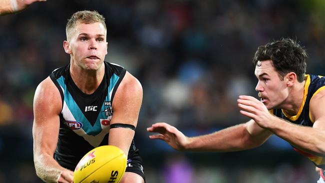 Dan Houston fires off a handball under pressure from Crow Mitch McGovern. Picture: Mark Brake/Getty Images