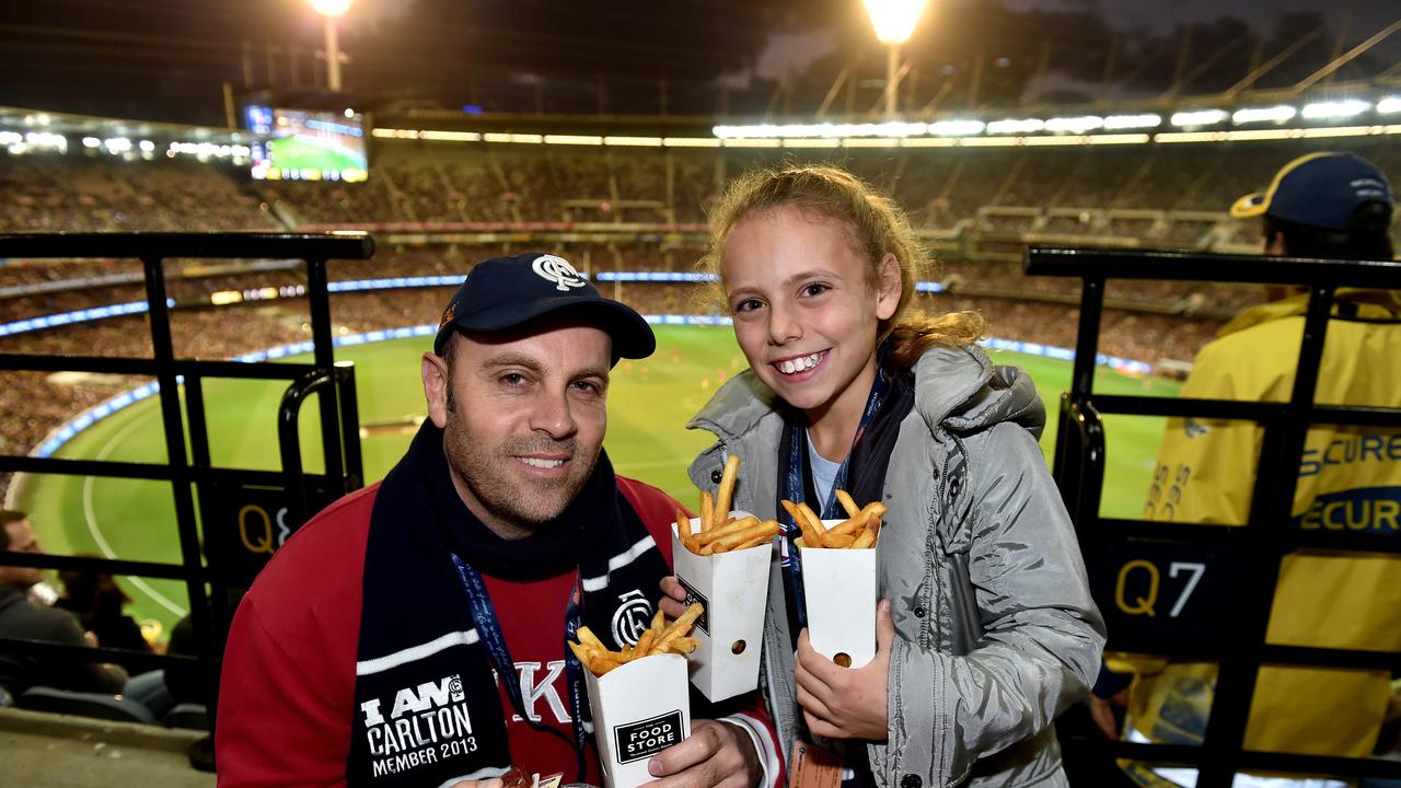 Dean Jordan with his daughter Ava enjoy some of the food on offer at MCG. Picture: Jay Town