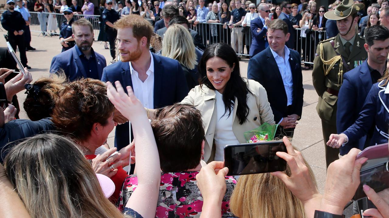 Prince Harry and a glowing Meghan Markle have been greeted by thousands of royal fans beneath the sails of Sydney’s iconic Opera House.