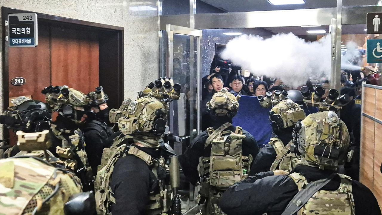 A National Assembly staff sprays fire extinguishers to block soldiers entering the main hall of the National Assembly. Picture: Jo Da-un/Yonhap/AFP