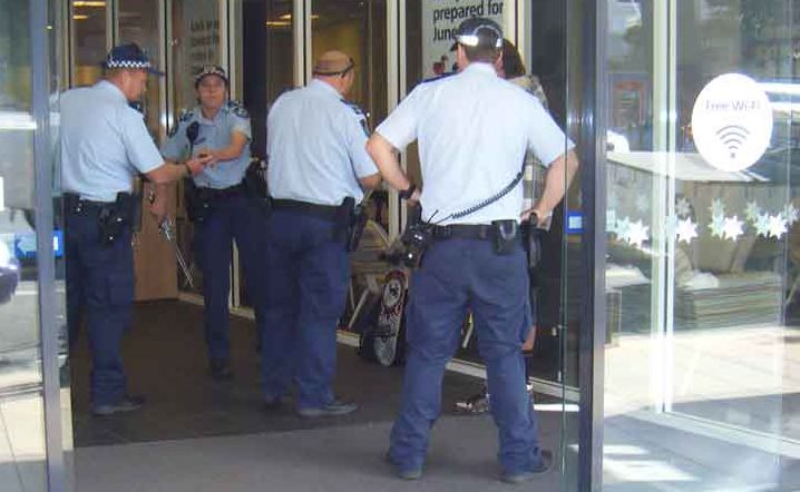 Police officers seize two swords from a man in the Toowoomba CBD.