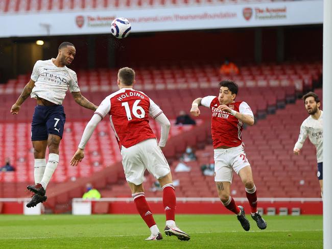 Manchester City's English midfielder Raheem Sterling (L) jumps to head home the opening goal of the English Premier League football match between Arsenal and Manchester City at the Emirates Stadium in London on February 21, 2021. (Photo by Julian Finney / POOL / AFP) / RESTRICTED TO EDITORIAL USE. No use with unauthorized audio, video, data, fixture lists, club/league logos or 'live' services. Online in-match use limited to 120 images. An additional 40 images may be used in extra time. No video emulation. Social media in-match use limited to 120 images. An additional 40 images may be used in extra time. No use in betting publications, games or single club/league/player publications. /