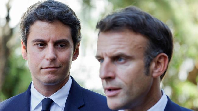 Gabriel Attal (L) looks at France's President Emmanuel Macron (R). (Photo by Ludovic MARIN / POOL / AFP)